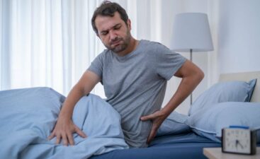 Man lying in bed and suffering from back pain